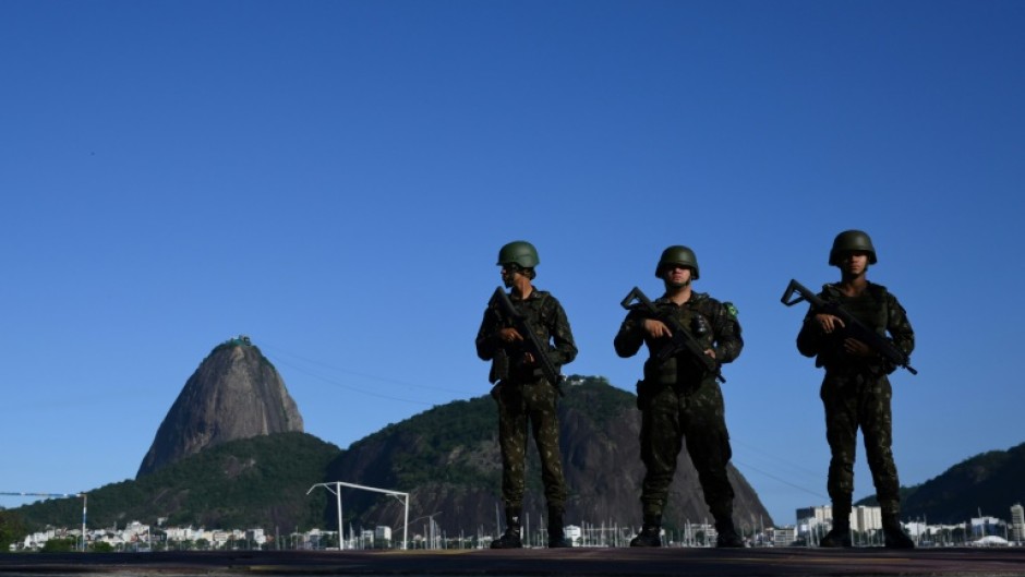 Brazilian army soldiers stand guard on Botafogo beach with the Sugar Loaf mountain in the background during the G20 Summit in Rio de Janeiro