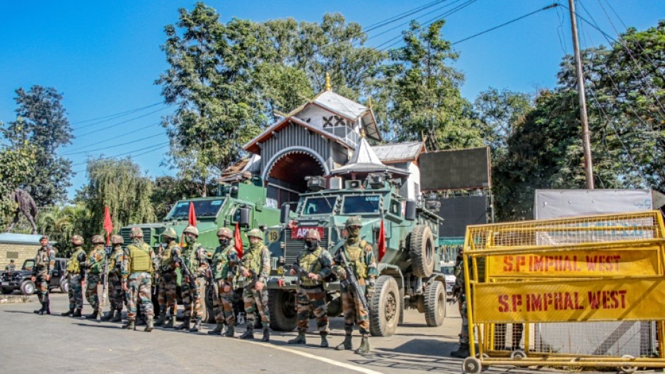 Army personnel stand guard Tuesday during a curfew in Imphal, in India's northeastern state of Manipur