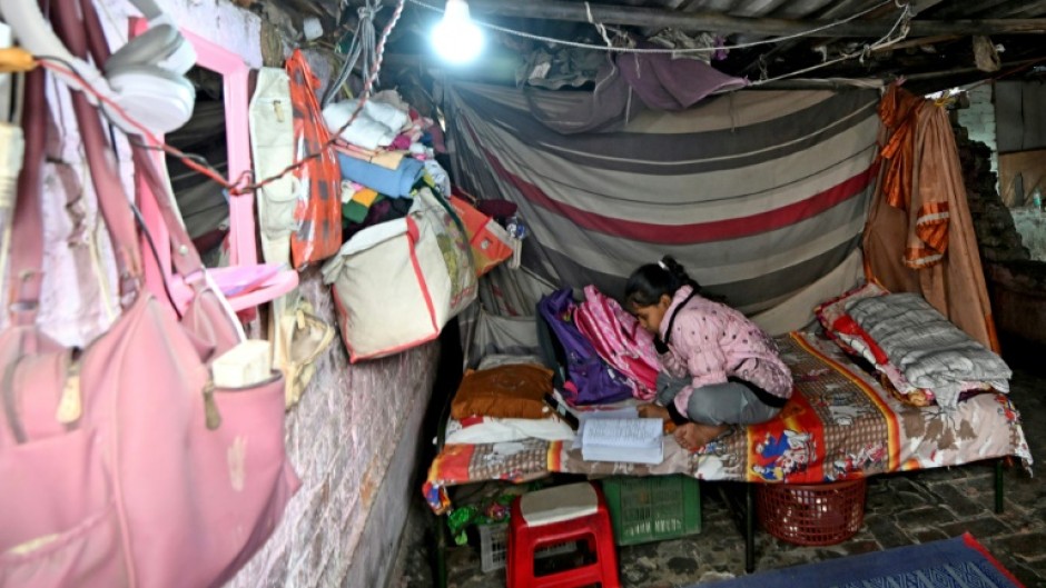 Confined to her home by the toxic smog choking India's capital, Harshita Gautam attends an online class on a mobile phone