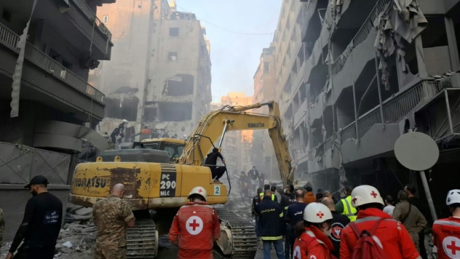 Rescuers use an excavator to clear the rubble following an Israeli air strike in Beirut's Basta neighbourhood Saturday