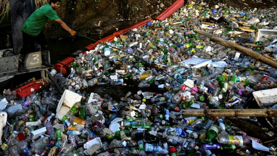 An NGO employee works on a gigantic hydraulic and solar-powered machine that collects garbage from the Juan Diaz River in Panama City