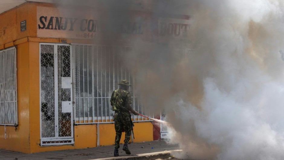 A Mozambique soldier tries to put out a burning tyre during a protest in Maputo Wednesday