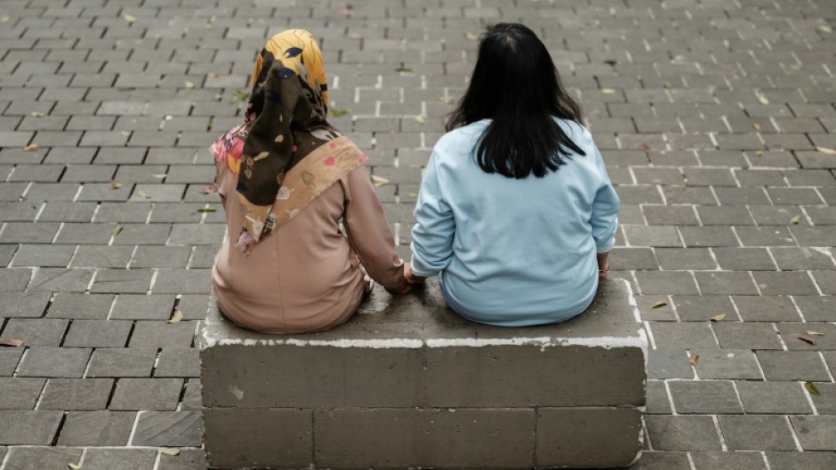 Two Indonesian women whose husbands are being forced to work as scammers in Myanmar spoke to AFP in Jakarta