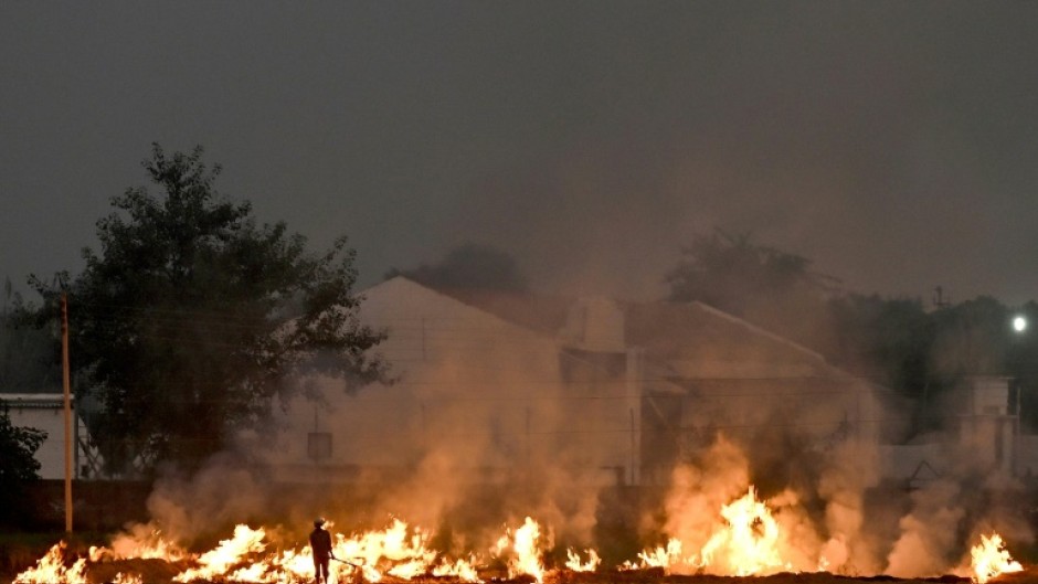 Burning straw stubble, a common but illegal practice in India, sends acrid smoke drifting over the country's densely populated north