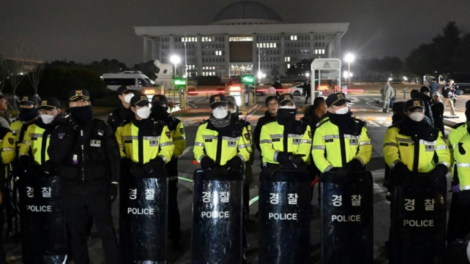 Police stand guard in front of the main gate of the National Assembly in Seoul after President Yoon Suk Yeol declared emergency martial law