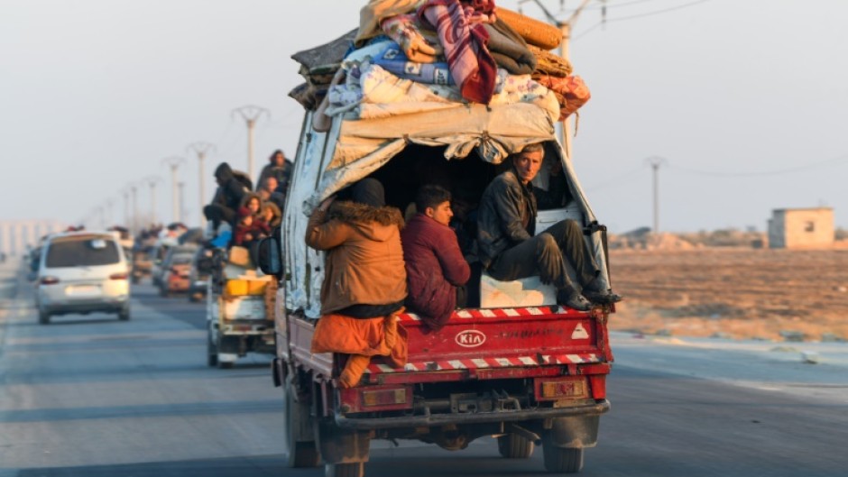 Displaced Syrian Kurds drive vehicles loaded with belongings on the Aleppo-Raqqa highway to flee areas on the outskirts of the northern city of Aleppo