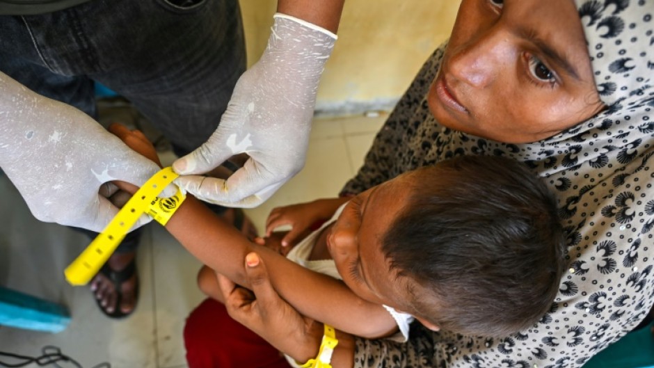 Rohingya refugees receive identity wristbands from UNHCR staff at a temporary shelter in Labuhan Haji, Indonesia