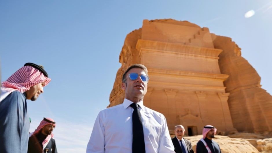 A world away from the crisis, French President Emmanuel Macron strolled through the desert sands of the Al-Ula oasis on a state visit to Saudi Arabia, marvelling at ancient landmarks