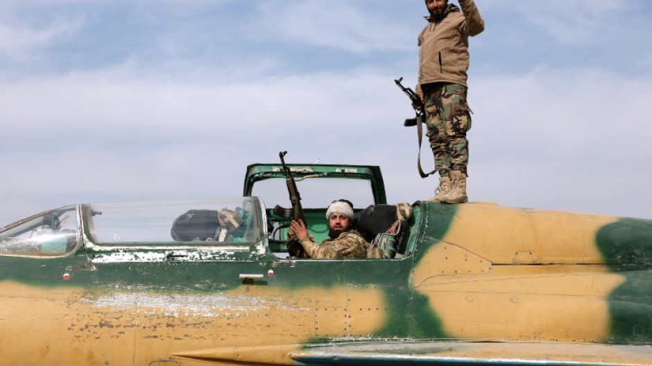 Rebel fighters at a military airbase seized from the government, near the central city of Hama