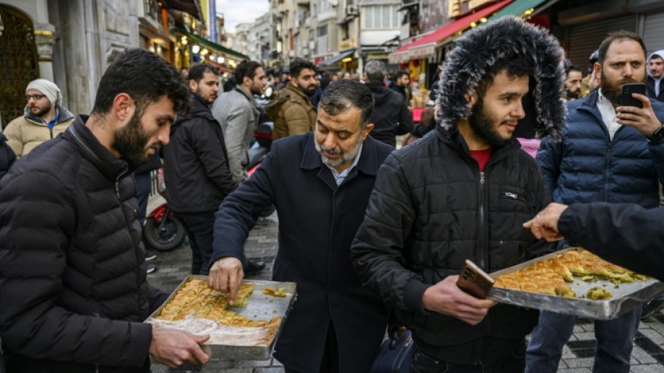 Syrians hand out baklavas in Istanbul to celebrate the reported fall of President Bashar al-Assad