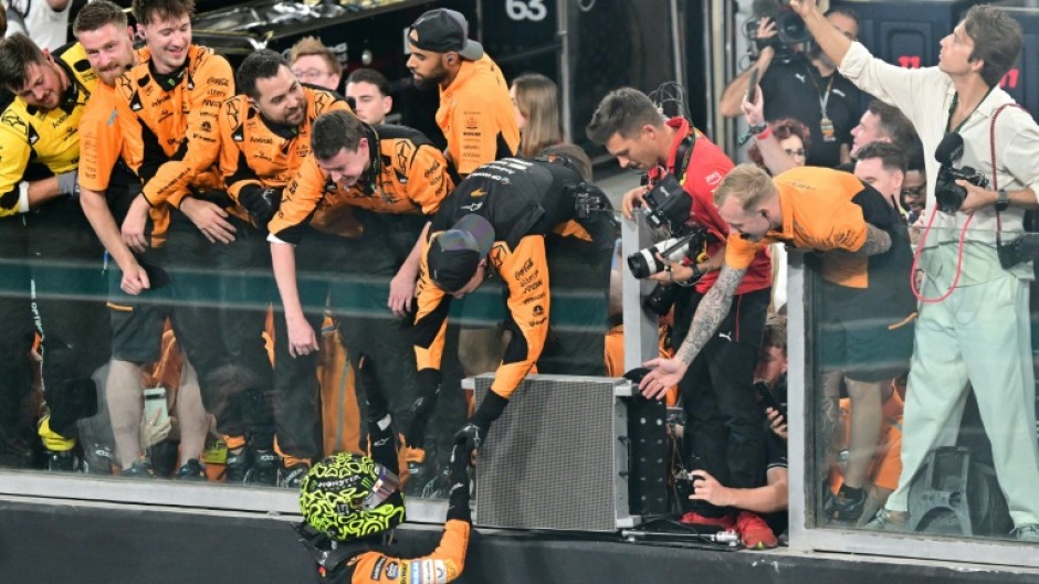 Lando Norris celebrates with the McLaren crew after winning the Abu Dhabi Grand Prix to seal the constructors' title