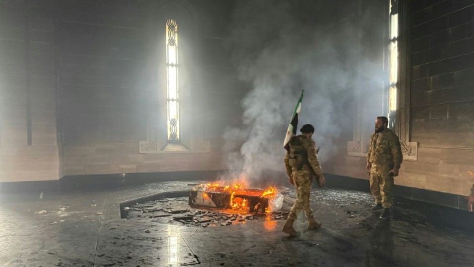 Rebel fighters set fire to the tomb of Assad's father and predecessor Hafez in their home village of Qardaha