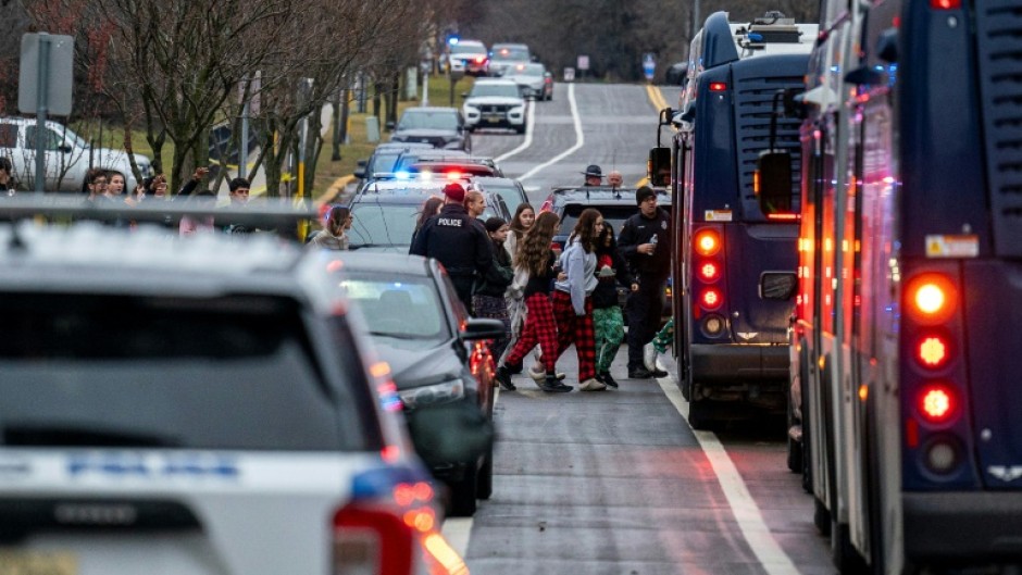 Students are escorted to a bus so they can be reunited with their parents after a deadly school shooting in Madison, Wisconsin on December 16, 2024 