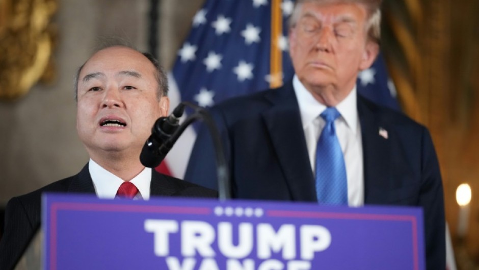 SoftBank CEO Masayoshi Son delivers remarks while US President-elect Donald Trump looks on at Mar-a-Lago in Florida on December 16, 2024