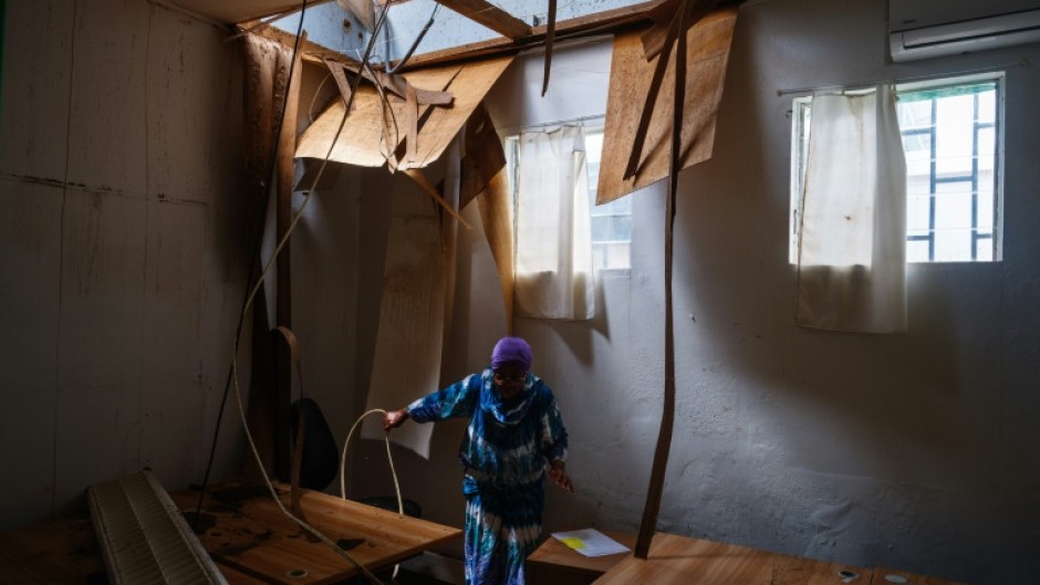 A worker cleans a room whose roof has collapsed at Mayotte's hospital