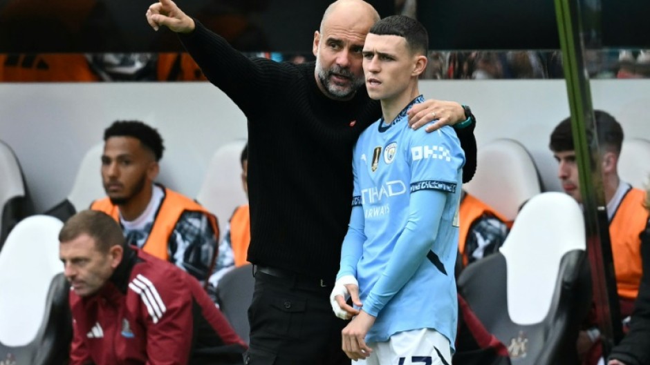 Manchester City manager Pep Guardiola speaks with Phil Foden