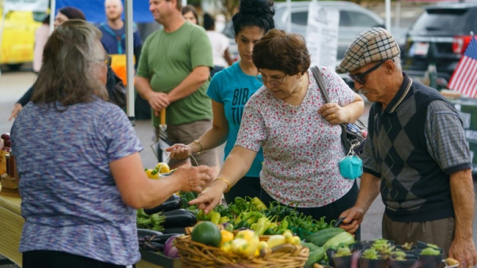 People shop for fresh produce and food at a farmer's market on June 29, 2021, in Homewood, Alabama