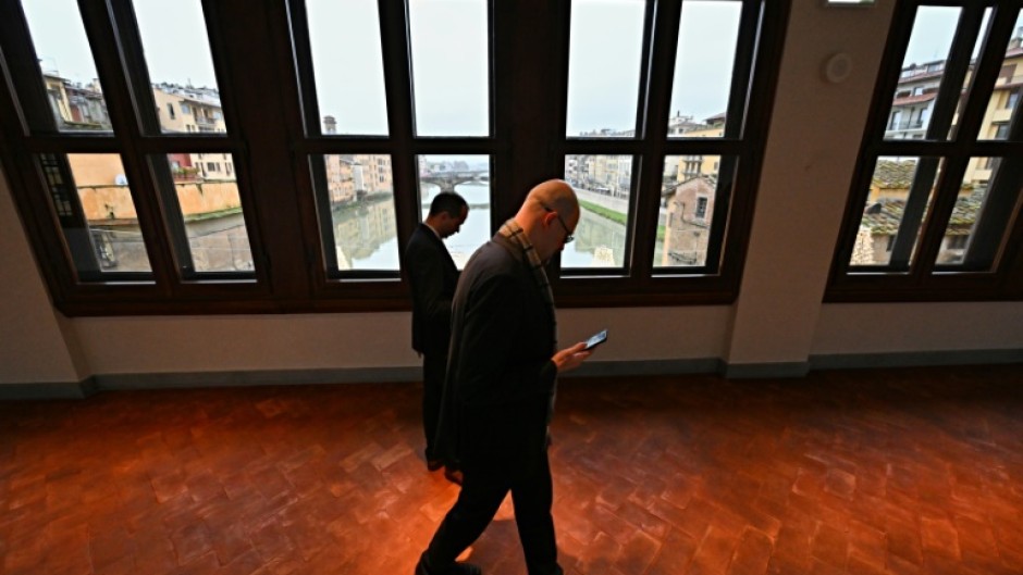 People walk in the Vasari Corridor gallery, in the center of Florence