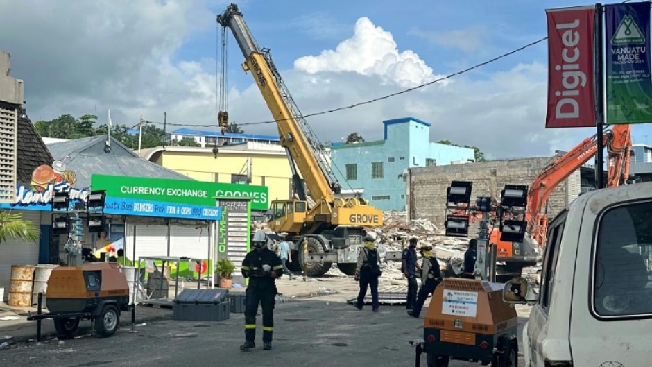 Rescue workers are seen on December 19, 2024 at a collapsed building from Vanuatu's first earthquake, in a photo taken and released by the Australian Department of Foreign Affairs and Trade