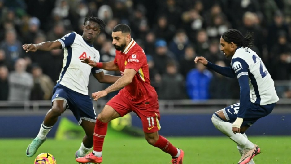 Liverpool star Mohamed Salah (C) bursts between  Yves Bissouma (L) and Djed Spence of Tottenham Hotspur during a  Premier League match in London on December 22, 2024.
