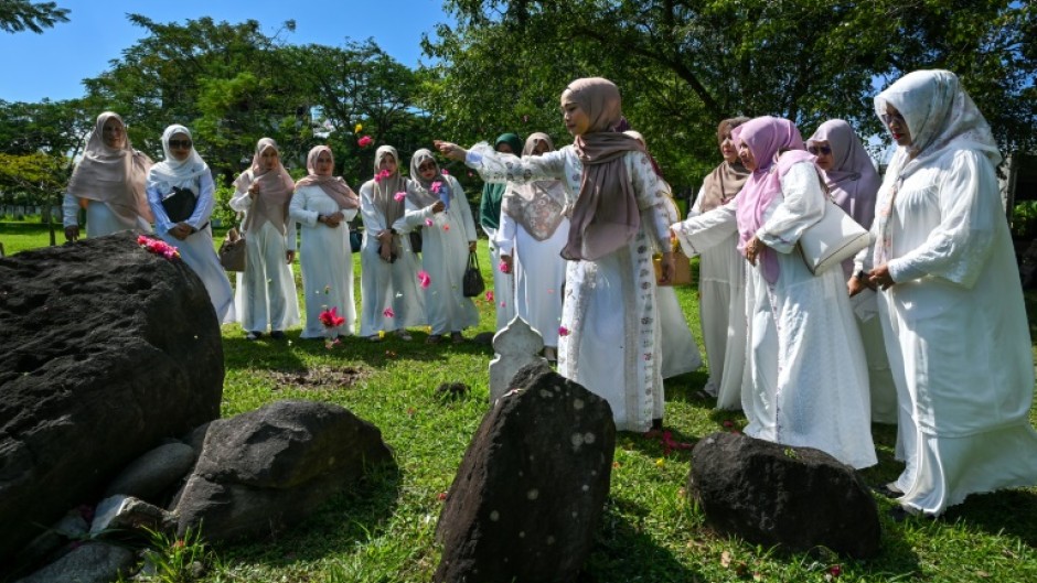 Women prayed for relatives who lost their lives in the 2004 Indian Ocean tsunami at a mass grave in Indonesia