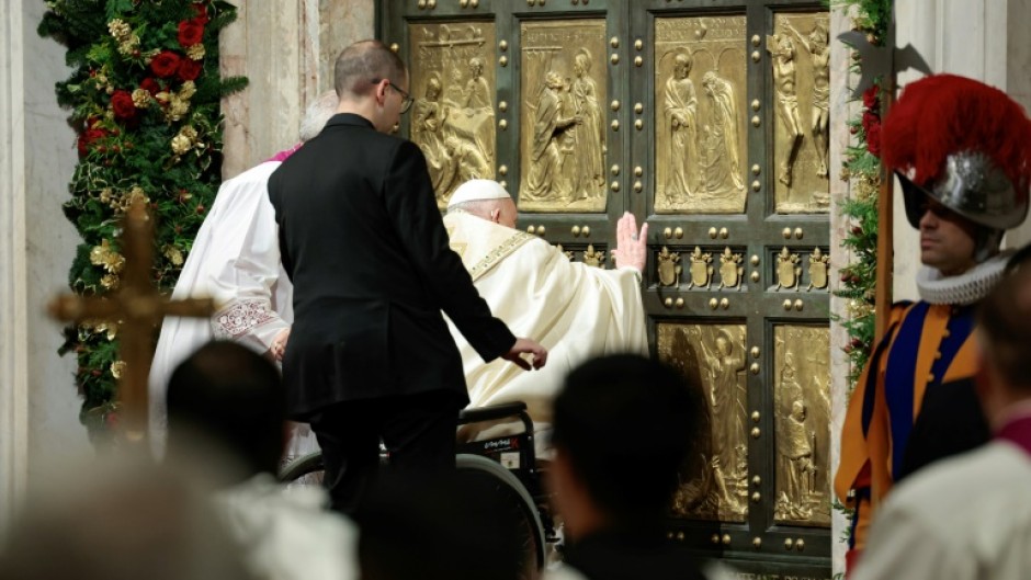 Pope Francis opens the Holy Door of St Peter's Basilica during a ceremony to mark the launch of Jubilee 2025