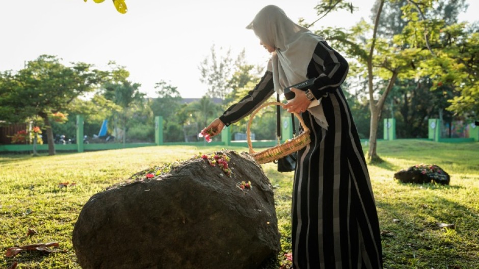 Some Indonesians sprinkled petals at mass graves in Aceh to mark the tsunami anniversary