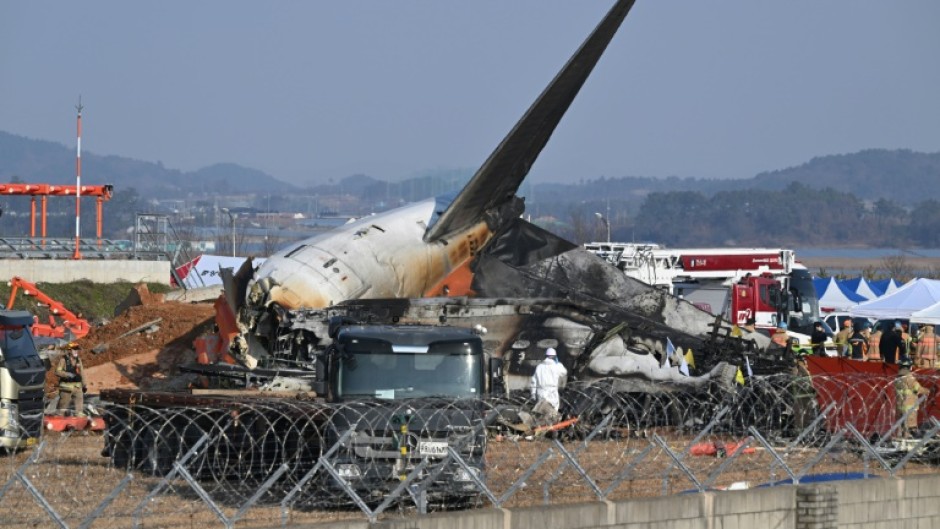 Firefighters and rescue personnel work near the wreckage of the crashed Jeju Air Boeing 737-800 