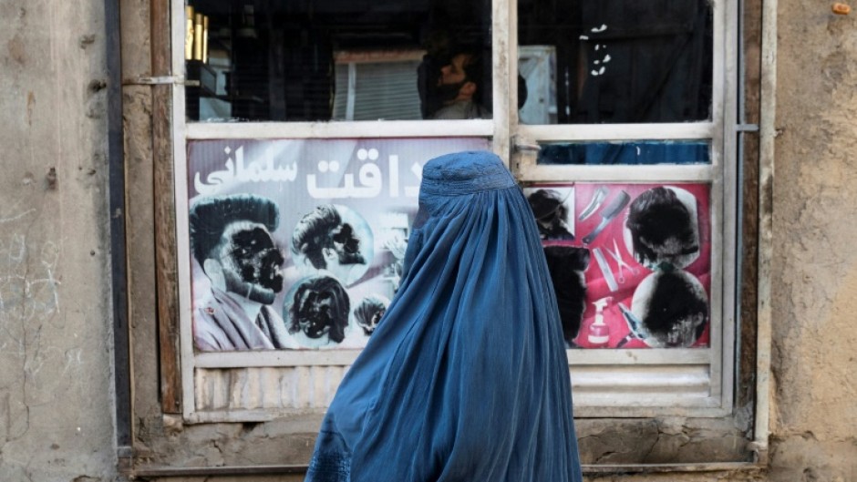 An Afghan woman stands at a window in Kabul on January 31, 2024