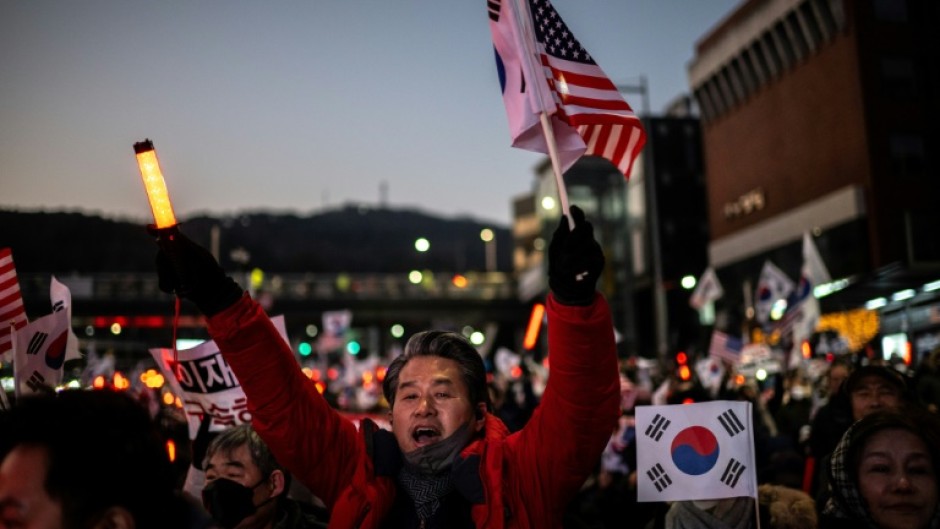 People wave US and South Korean flags during a rally to support impeached South Korea's President Yoon Suk Yeol