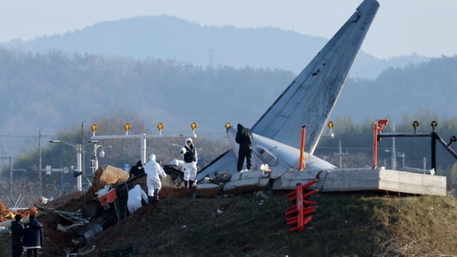 Officials investigate the site where a Jeju Air Boeing 737-800 aircraft crashed and burst into flames at Muan airport