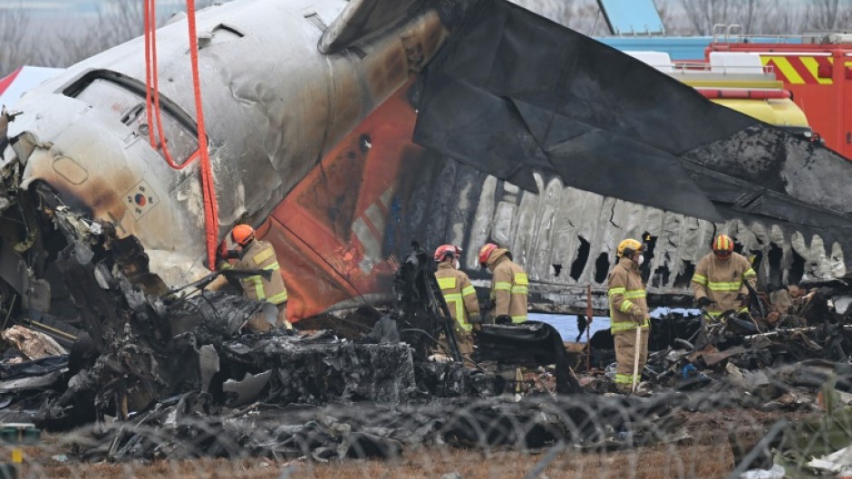 Firefighters and recovery teams work at the scene where a Jeju Air Boeing 737-800 series aircraft crashed and burst into flames at Muan International Airport