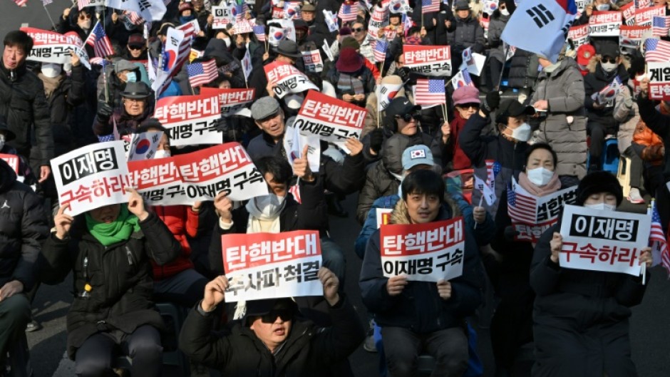 Supporters of impeached South Korea President Yoon Suk Yeol hold up anti-impeachment placards