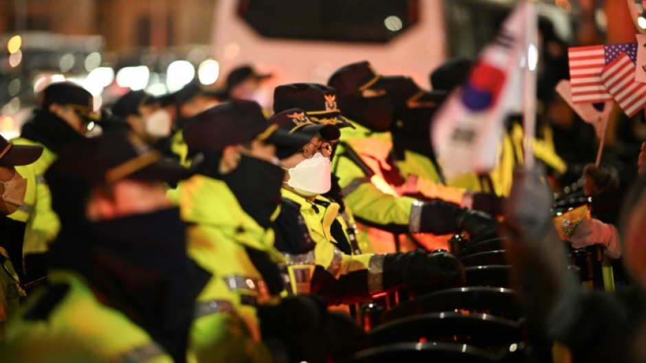 Police officers set up barricades in front of people taking part in a rally to support South Korea's impeached president Yoon Suk Yeol