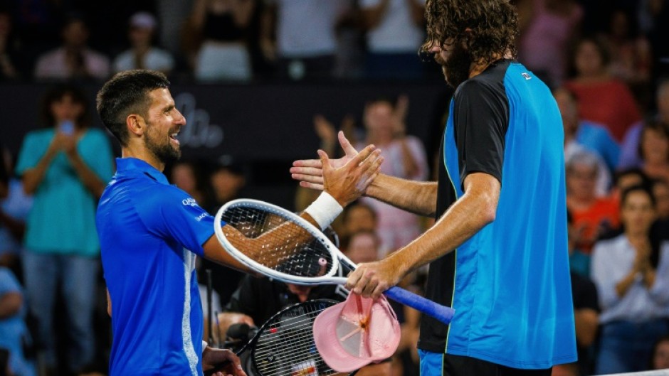 American Reilly Opelka (right) shakes hands with  Serbia's Novak Djokovic after beating him in the quarter finals of the Brisbane International