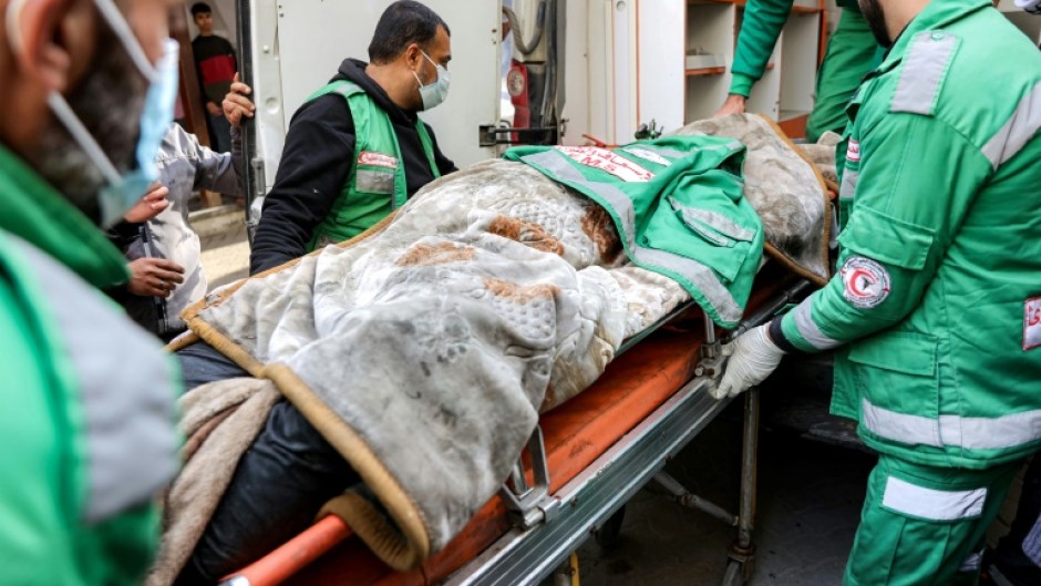 Palestine Red Crescent paramedics at Al-Ahli Arab Hospital in Gaza City move the body of their colleague Mahmud al-Muhadad, after Israeli air strikes