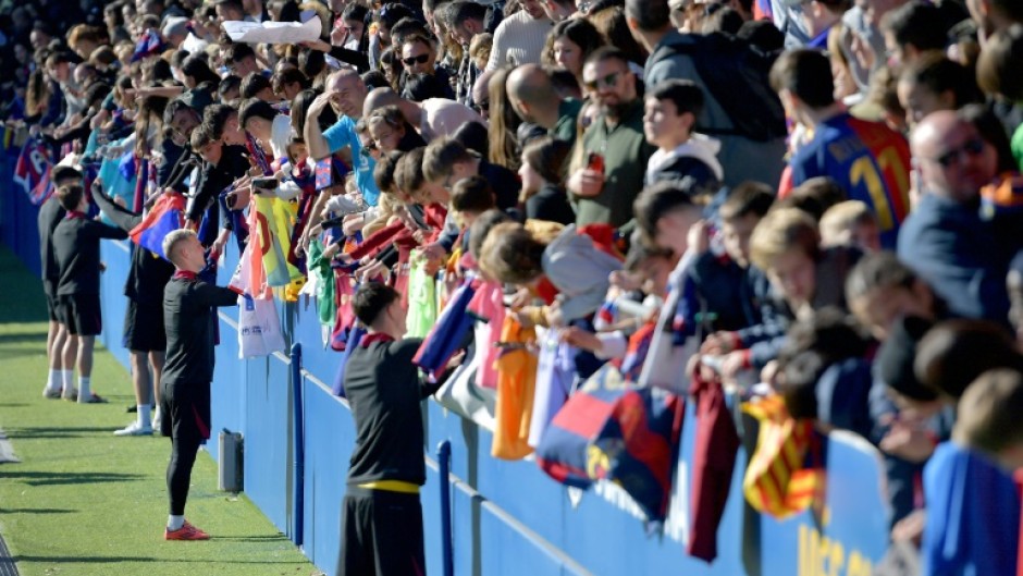 Barcelona's Spanish forward Dani Olmo and teammates sign autographs for fans at an open training session