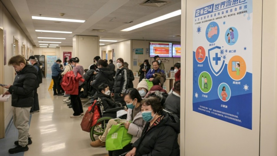 People wearing masks wait in the respiratory department of a Beijing hospital this week