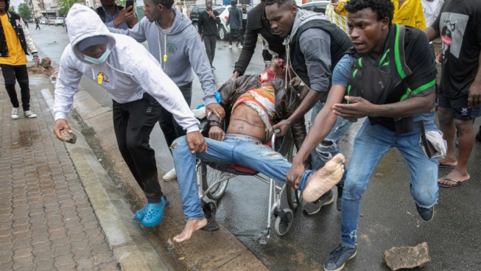 People rallied around a man shot during clashes with riot police in Maputo as large crowds turned out to welcome the opposition leader home