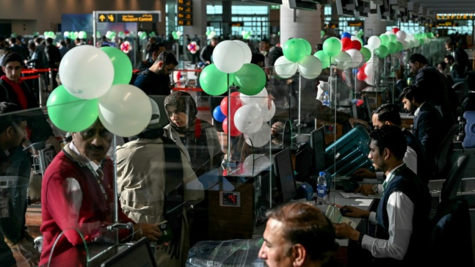 Passengers wait to board their Pakistan International Airlines (PIA) flight to Paris after EU authorities lifted a four-year ban on the flag carrier