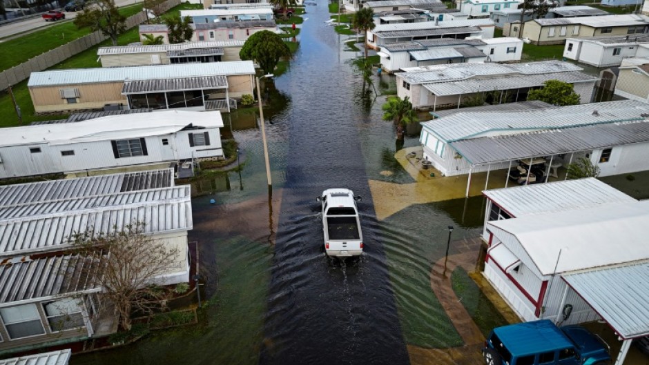 An aerial view shows a truck driving through a flooded street in the aftermath of Hurricane Milton in South Daytona, Florida