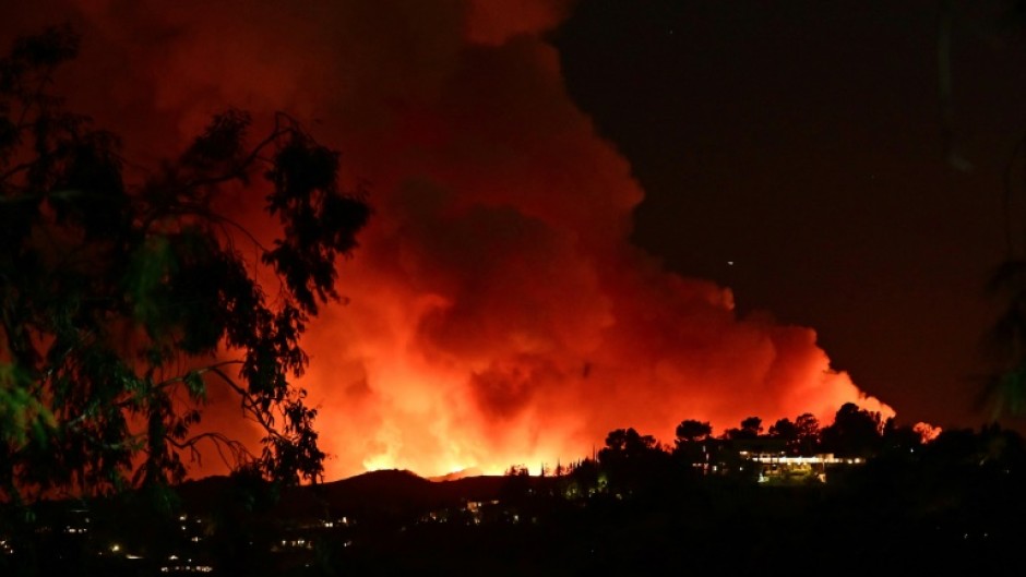 Smoke and flames from the Palisades Fire burn toward the Encino neighborhood of Los Angeles, California