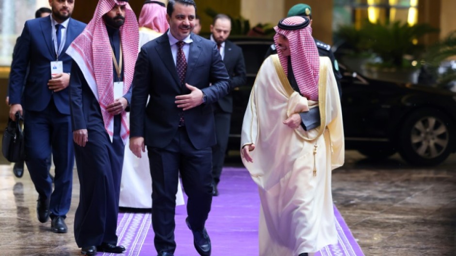 Saudi Foreign Minister Prince Faisal bin Farhan (R) welcomes his Syrian counterpart Asaad al-Shaibani (C) before attending the talks