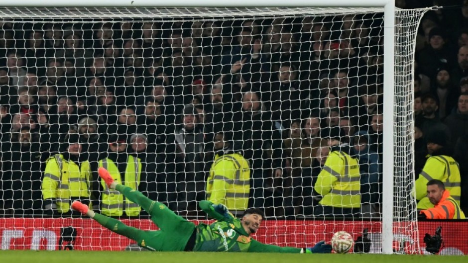 Man of the moment: Manchester United goalkeeper Altay Bayindir saves the penalty of Kai Havertz in the shootout