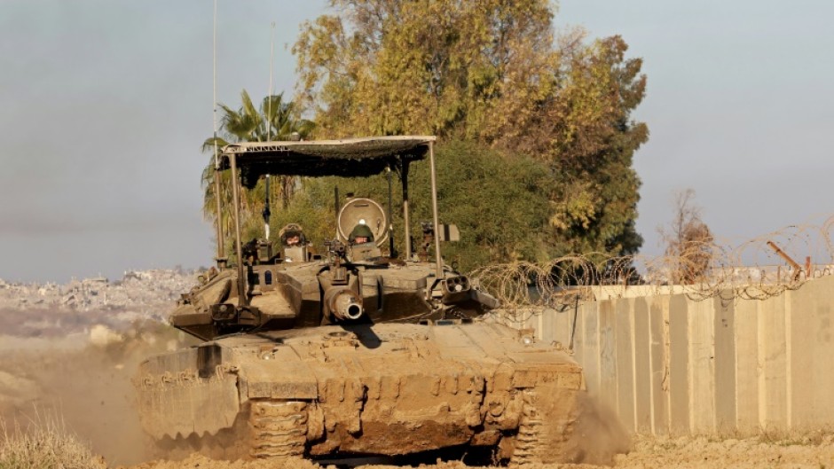 An Israeli tank drives into position near Israel's southern border with the Gaza Strip on January 14, 2025