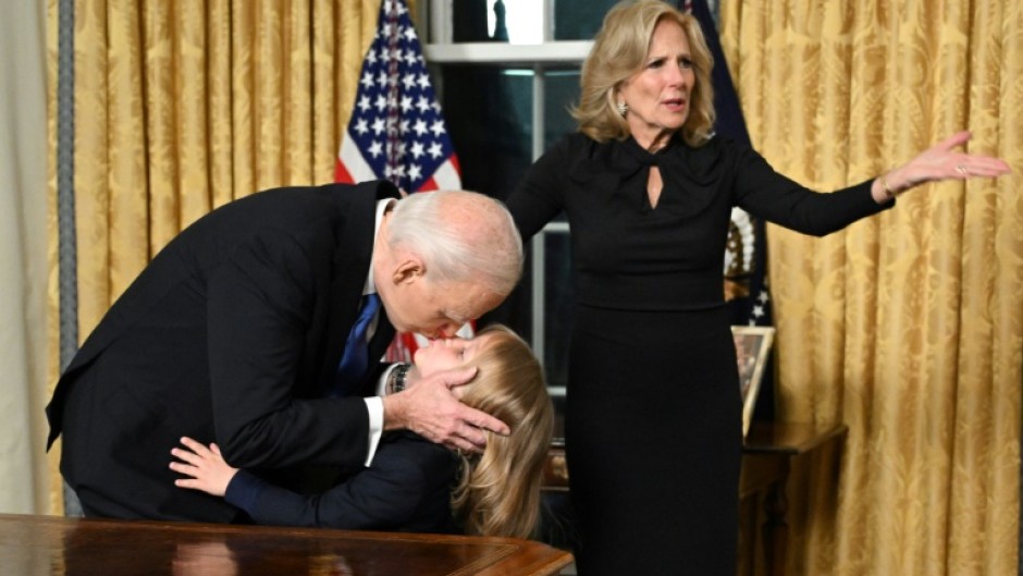 US President Joe Biden kisses his grand-son Beau Biden Jr. as First Lady Jill Biden gestures after the President delivered his farewell address to the nation from the Oval Office of the White House in Washington, DC, on January 15, 2025.