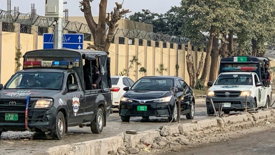 Police vehicles escort a car (C) carrying an accountability court judge as they arrive at the Adiala prison in Rawalpindi before the graft case hearing