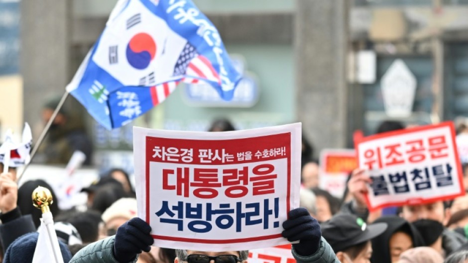 Outside the court, AFP journalists saw crowds of Yoon's backers waving flags and holding 'release the president' placards