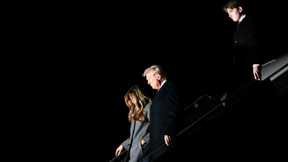 US President-elect Donald Trump, his wife Melania and son Barron arrive at Dulles International Airport in Virginia on January 18, 2025