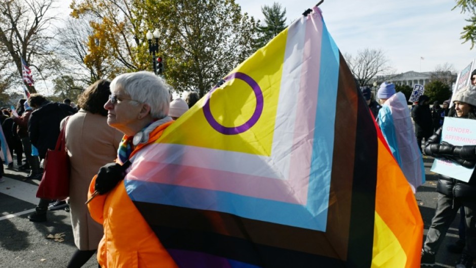 People hold LGBTQ+ flags outside the US Supreme Court